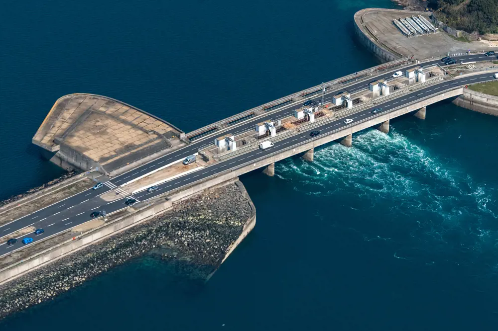 A photograph of a main road crossing a dam, which is connected to the tidal power station on the Rance River estuary. 