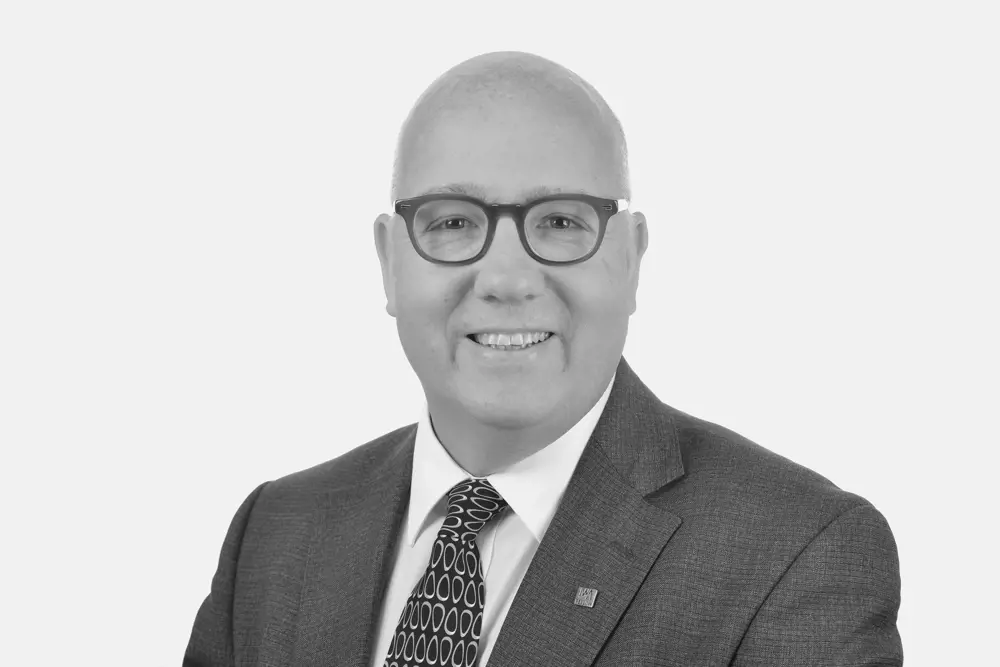 A black and white headshot of Professor Simon Pollard.