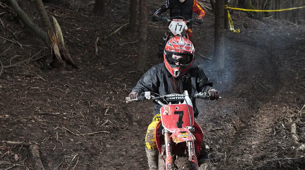 A young person riding a motorbike off-road. 