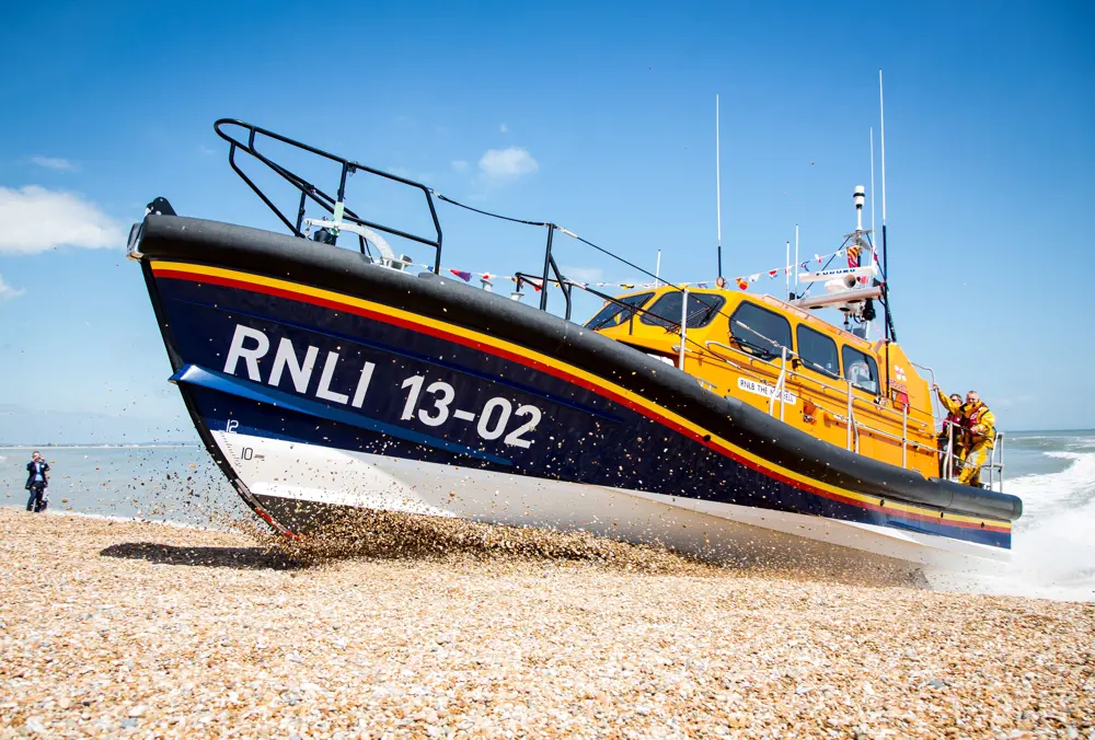 The Shannon boat launching itself onto a sandy beach.