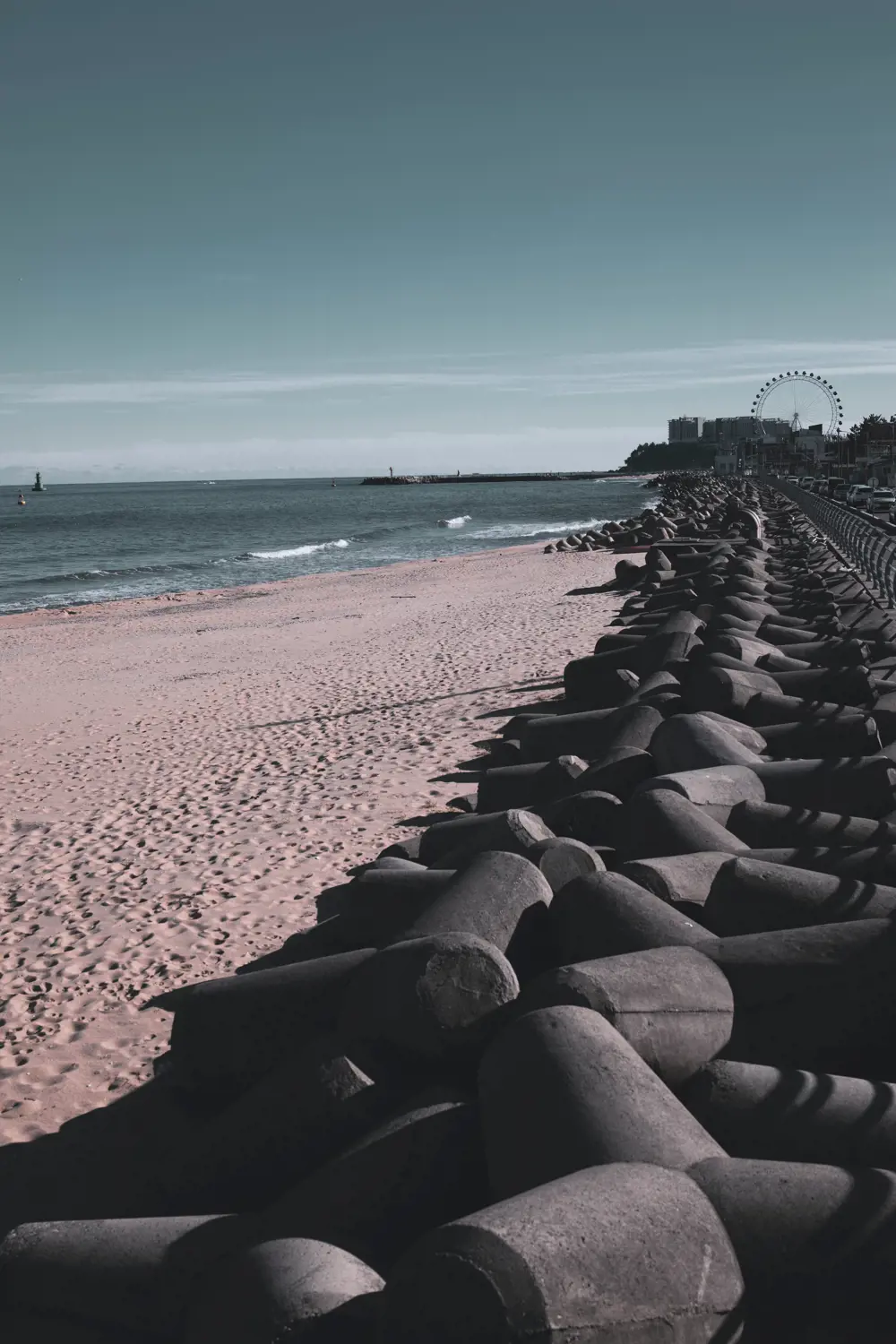 An array of concrete tetrapods on a beach, stretching into the distance.