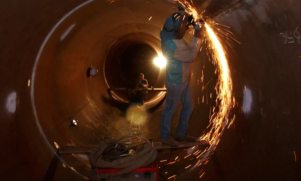 A welder in a tunnel at the CERN Neutrinos to Gran Sasso decay tube.