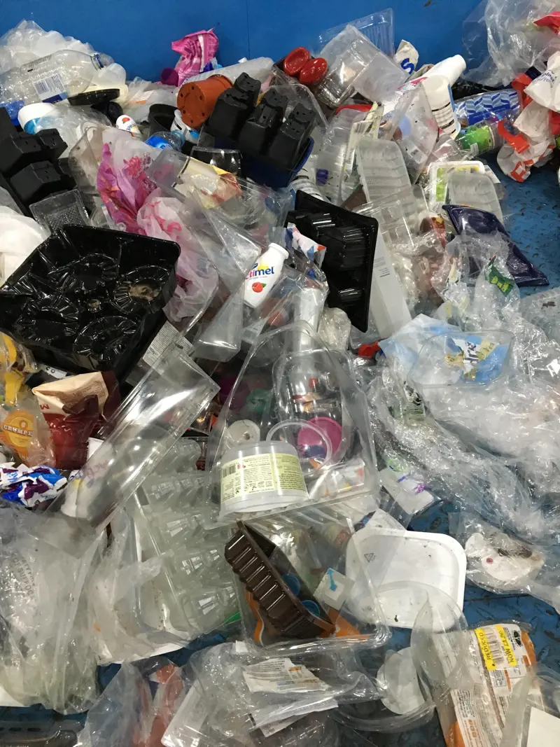 Plastic waste at the bottom of a blue container.