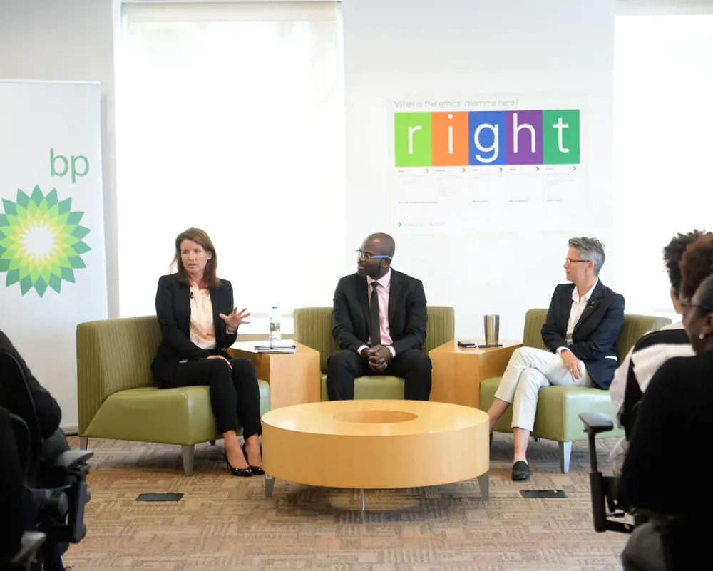  Leigh-Ann Russell FREng sitting on a chair in smart attire next to two other people, with the BP logo in the background.