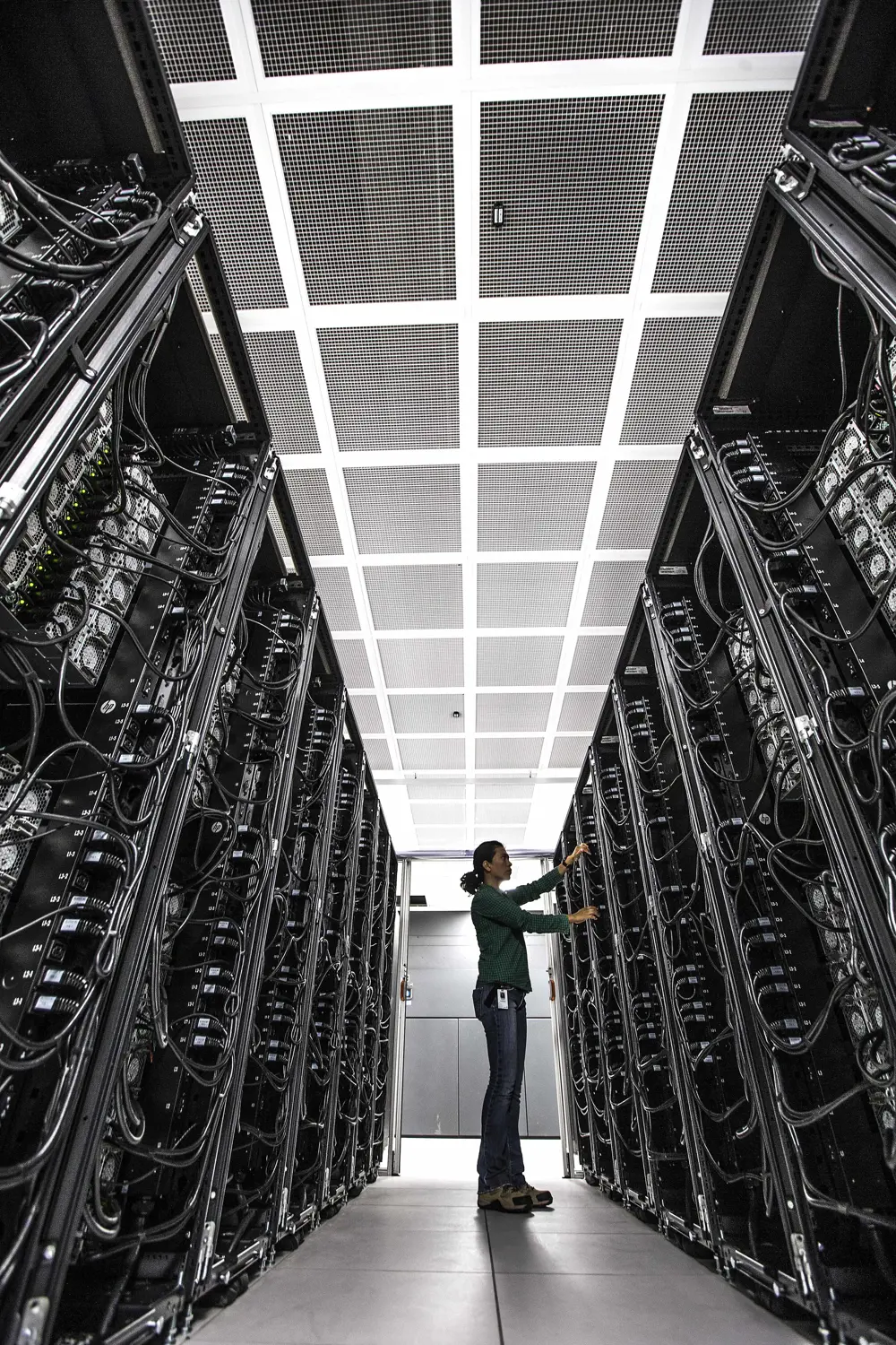 A person standing in a server room at the centre for high performance computing.