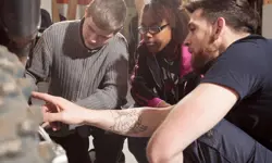 Adolescents being taught the mechanics of a bike.